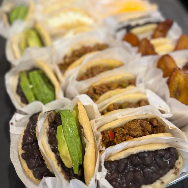 A tray of La Arepa's Venezuelan arepas with various fillings like black beans, avocado, and meat.