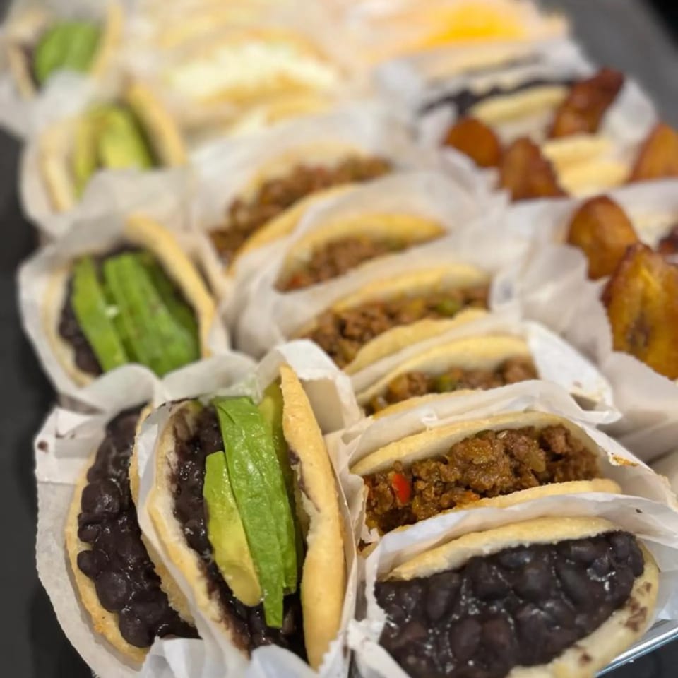 A tray of La Arepa's Venezuelan arepas with various fillings like black beans, avocado, and meat.