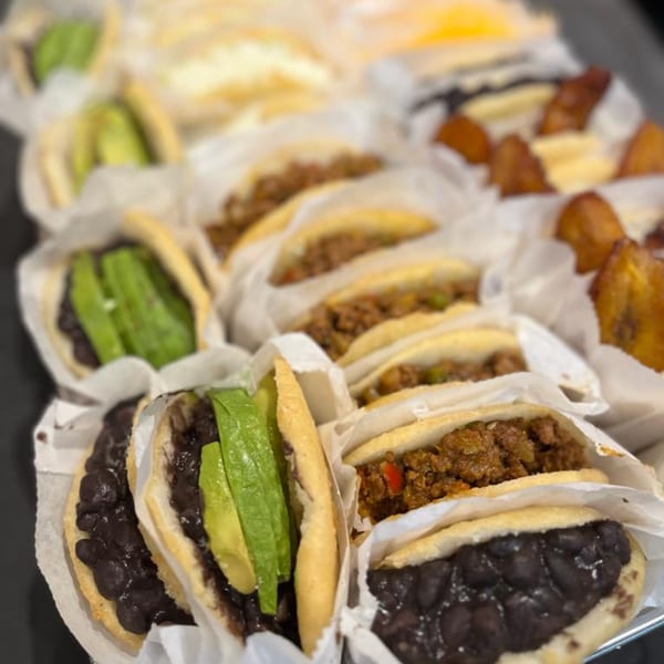 A tray of La Arepa's Venezuelan arepas with various fillings like black beans, avocado, and ground meat.